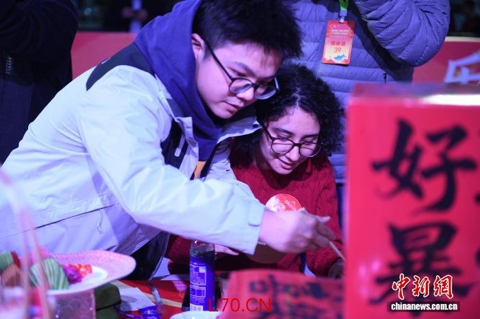 2月22日，“乐购新春·福满超级皖”主题活动在合肥骆岗中央公园启幕。图为羽茉(右)和男友品尝安徽美食。中新社记者 赵强 摄