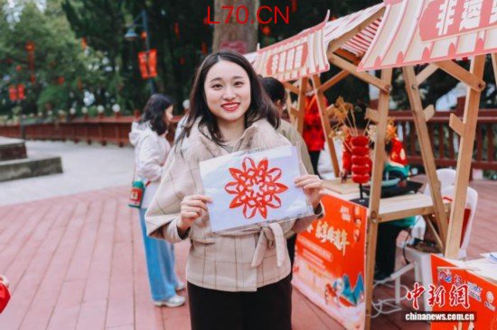 图为游客展示剪纸作品。翁榕飞 摄