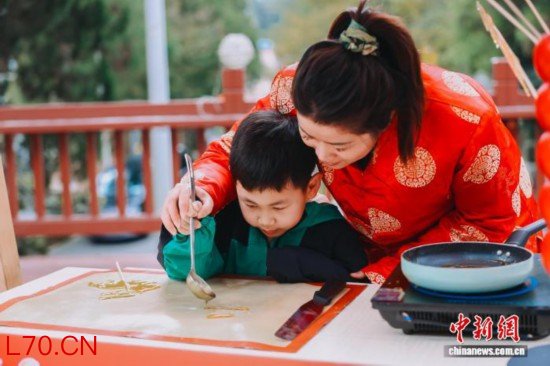 图为小朋友体验糖画制作。翁榕飞 摄
