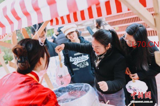 图为游客体验漆扇制作。翁榕飞 摄