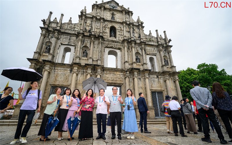 图为与会代表们纷纷在大三巴牌坊留影。 澳门特区政府新闻局供图