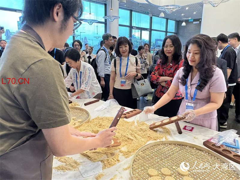 图为与会代表们饶有兴致地学做杏仁饼。 人民网记者 富子梅摄